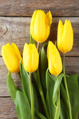 Yellow tulips on grey wooden background