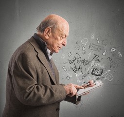 Aged reads books with tablet