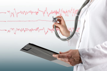 Female doctor's hand holding stethoscope and clipboard on blurre