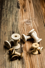 empty wooden sewing spools on old wood background