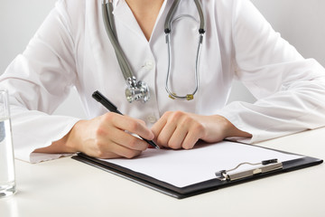 Female doctor's hand holding green apple isolated on white 