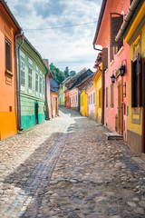 Fototapeta na wymiar Stone paved old streets with colored houses from Sighisoara fort
