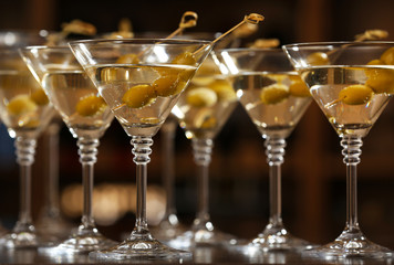 Glasses of cocktails on bar background