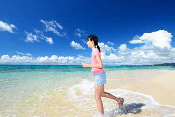 南国沖縄のビーチで遊ぶ女の子 