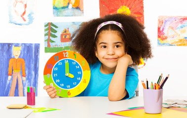 Small African girl holding showing time