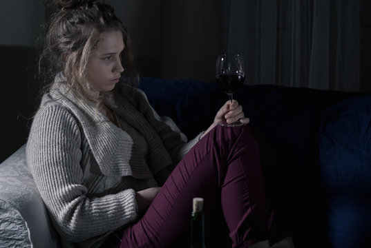 Abandoned woman drinking wine alone
