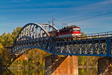 Train on the bridge crossing river .