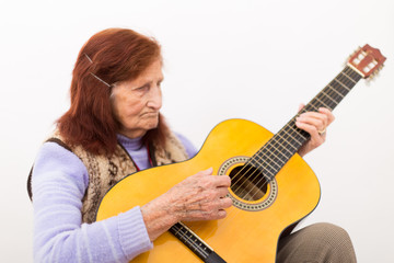 Fototapeta premium Funny elderly lady playing acoustic guitar.