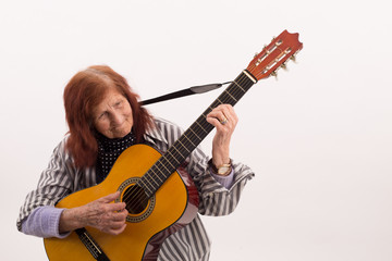 Obraz premium Funny elderly lady playing acoustic guitar.