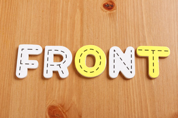 FRONT, spell by woody puzzle letters with woody background