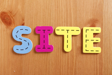 SITE, spell by woody puzzle letters with woody background