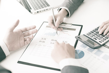 Two businessmen looking at report and having a discussion in off