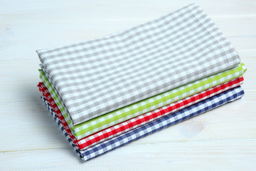 Multi-colored kitchen towels, on a white wooden background