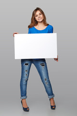Fototapeta premium Full length of beautiful woman standing behind, holding white bl