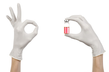 doctor's hand in a white glove holding a red vial of liquid