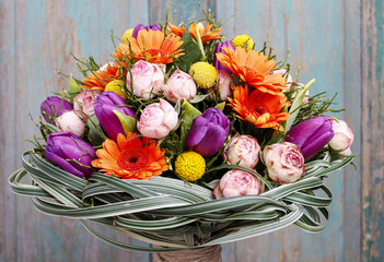 Bouquet of orange gerbera daisies, violet tulips and pink roses