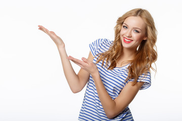 Smiling young slim tanned female showing open hand palm with cop