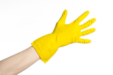 man's hand holding a yellow and wears rubber gloves in studio