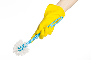 human hand holding a blue toilet brush in yellow gloves