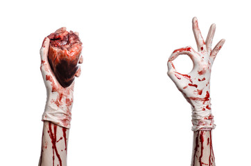 Bloody hand surgeon holding a human heart in a white gloves