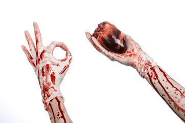 Bloody hand surgeon holding a human heart in a white gloves