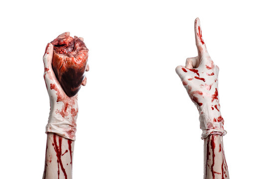 Bloody hand surgeon holding a human heart in a white gloves