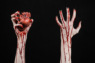 bloody hands with black nails holding bloody human heart