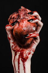 bloody hands with black nails holding bloody human heart - 83754074