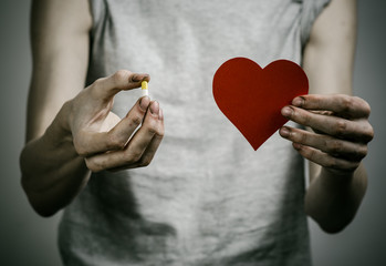 addict holding a narcotic pills on a dark background