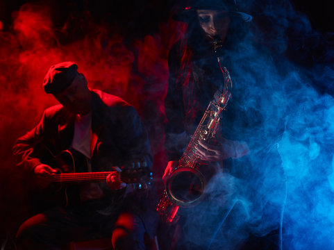 Beautiful young woman plays saxophone