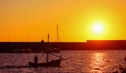 boat silhouette in Alghero harbor