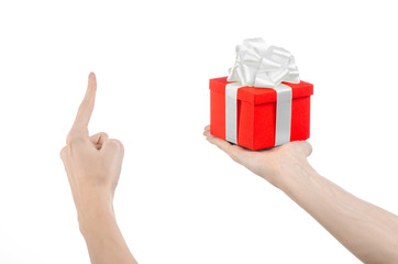 hand holding a gift wrapped in red box with white ribbon and bow