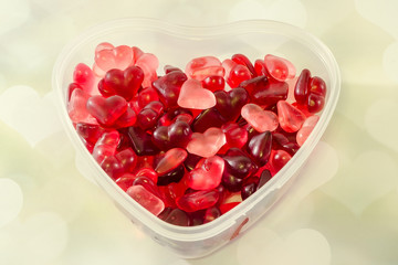 Colored jellys heart sweets in a heart shape transparent vase