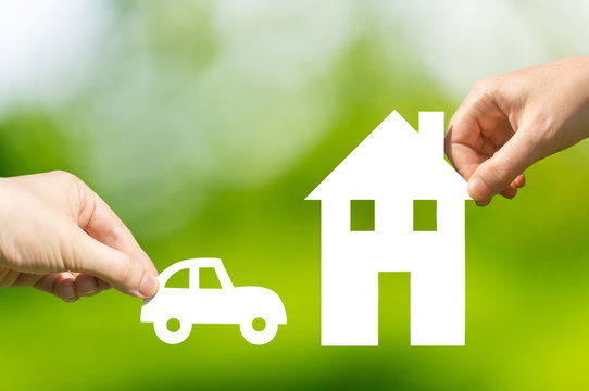 Hands Holding Cut Out Paper Car And House As Symbol Of Mortgage