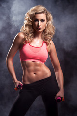 Fototapeta na wymiar Fitness woman standing with weights