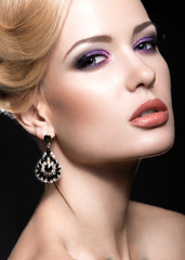 Beautiful girl with bright makeup and evening hairstyle. Picture taken in the studio on a gray background.