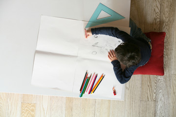 Bambino disegna su un foglio bianco