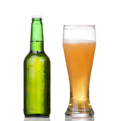 Chilled green bottle with condensate and a glass 
