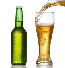 Chilled green bottle with condensate and a glass 