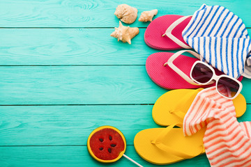 Frame of summer accessories and candy on blue wooden background. Top view