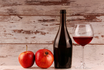 Red wine bottle on a wooden background, apple 