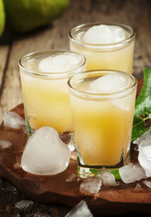 Pear fresh juice with ice in a heart-shaped and pear on a wooden