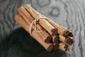 bunch of cinnamon sticks tied with twine, on rustic table