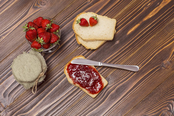 Strawberries and croissant on a wooden brown background