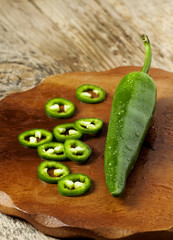 Spicy green pepper on a wooden cutting board, selective focus