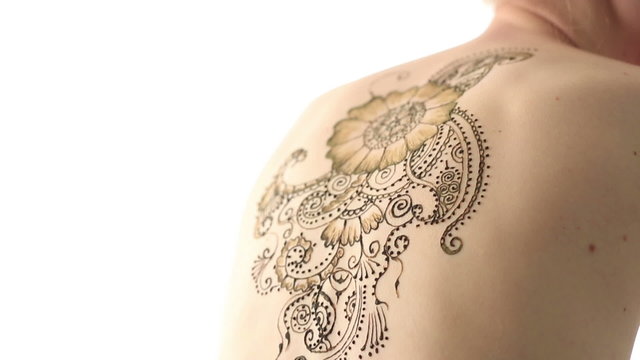 View of woman's back with beautiful henna pattern