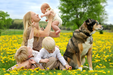 Mother and Three Children Playing in Flower Meadow