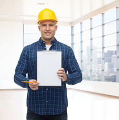 smiling male builder in helmet with clipboard