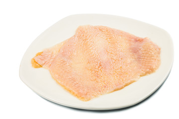 Chicken skin removed from breast meat on a plate