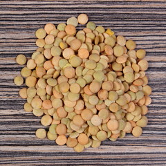 Heap of green lentil on wooden background